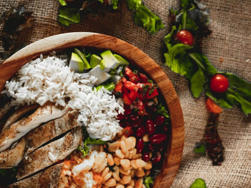 Bol de pollo con arroz y verduras frescas para una cena saludable