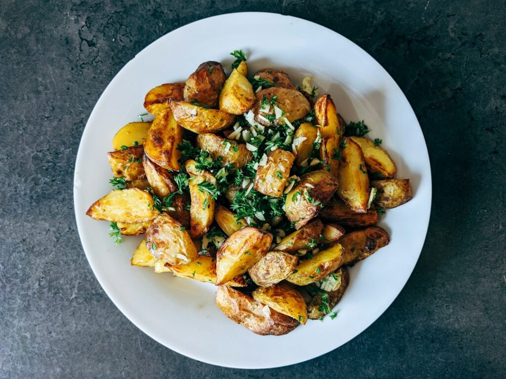 Plato de patatas doradas con verduras como idea para cocinar en freidora de aire